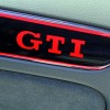 Weltpremiere am Woerthersee: Golf GTI Black Dynamic/Praezision im Detail - von Hand lackierter roter GTI-Schriftzug auf Tuerinnenverkleidung.