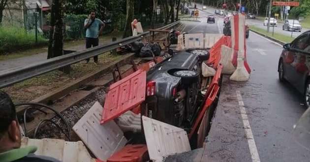 Car crashes into temporary barrier, falls into hole in road; driver and passenger not injured in incident